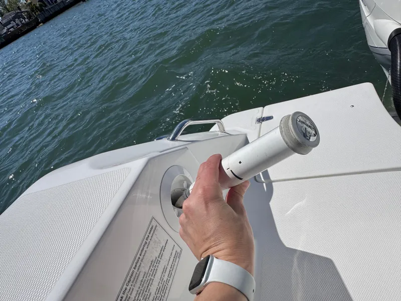 Slide: The Image of Hand holding a fuel nozzle on a 2018 Boston Whaler 330 Outrage boat. - 28