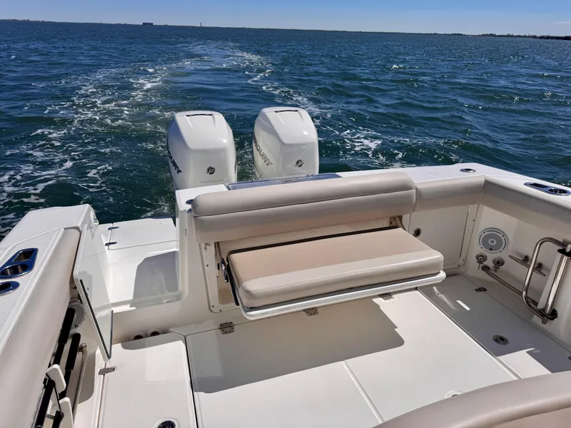 Slide: The Image of 2018 Boston Whaler 330 Outrage boat on open water, featuring dual engines and seating. - 3