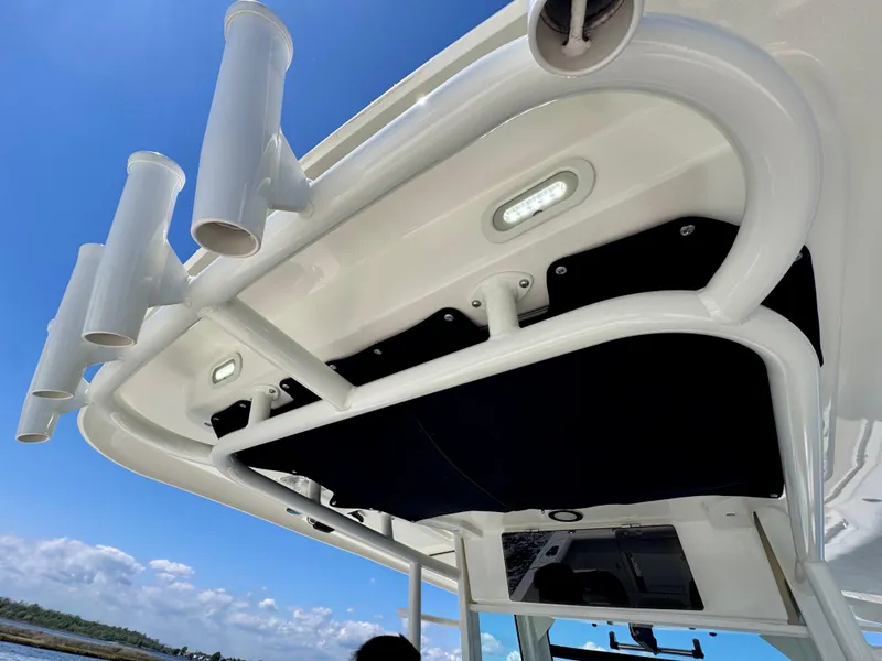 Slide: The Image of Boston Whaler 330 Outrage 2018 boat canopy with rod holders under clear blue sky. - 37