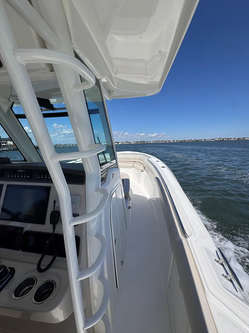 Slide: The Image of 2018 Boston Whaler 330 Outrage boat cruising on open water under clear blue sky. - 38