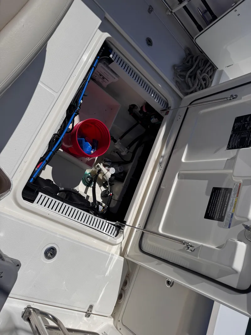 Slide: The Image of Open hatch of a 2018 Boston Whaler 330 Outrage showing interior storage and equipment. - 39