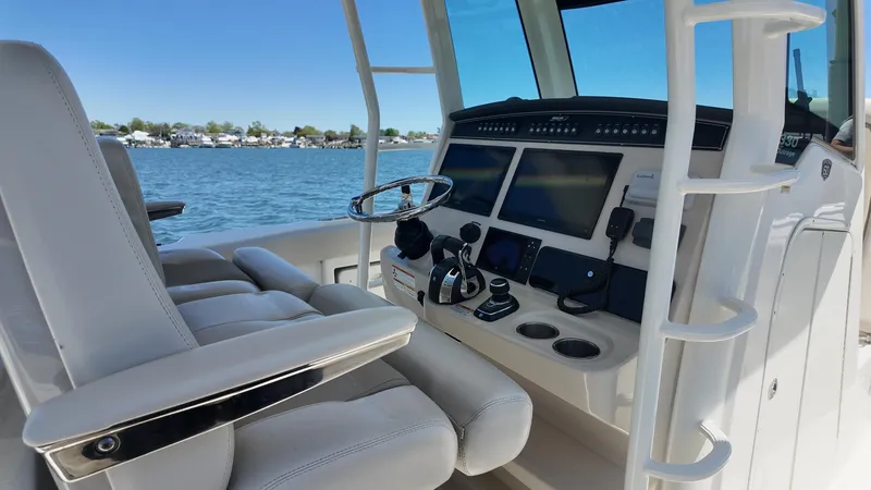 Slide: The Image of 2018 Boston Whaler 330 Outrage helm with modern controls and ocean view. - 4