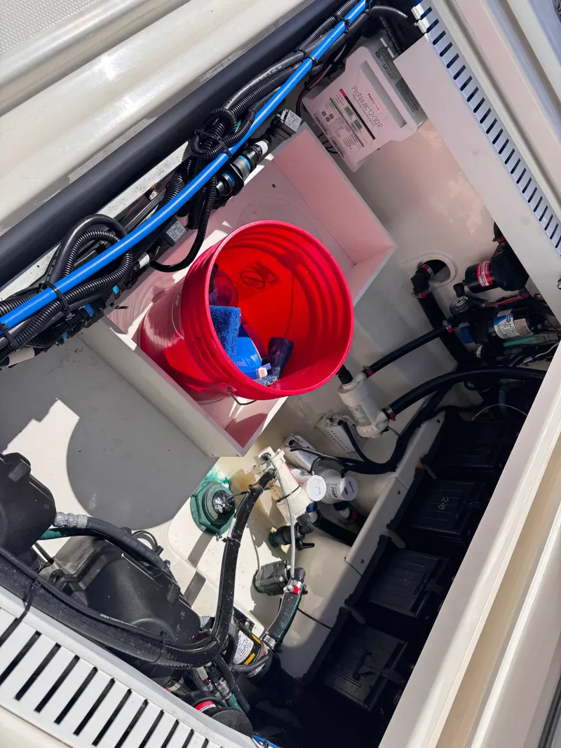 Slide: The Image of 2018 Boston Whaler 330 Outrage engine compartment with red bucket and wiring. - 40
