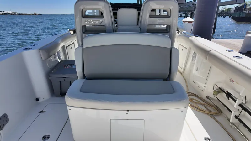 Slide: The Image of 2018 Boston Whaler 330 Outrage boat interior with seating, docked by the water. - 7
