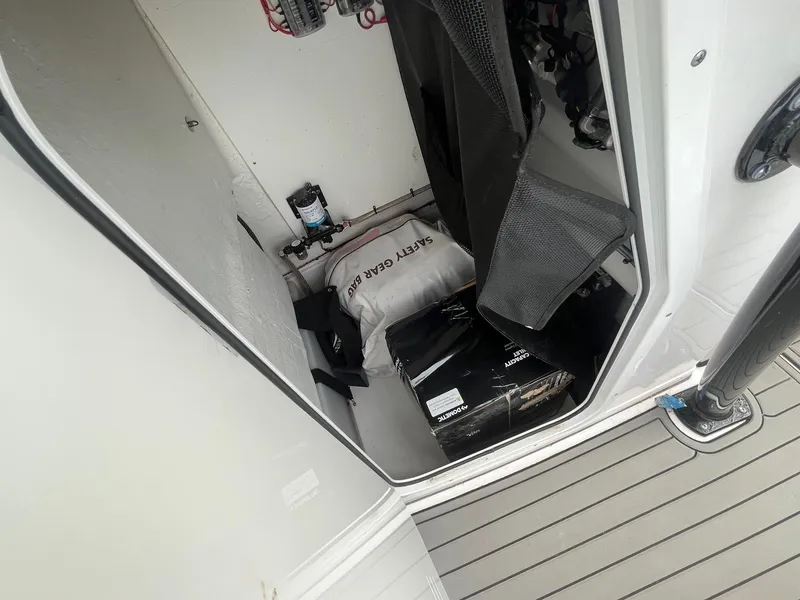 Slide: The Image of Storage compartment of a 2020 Sportsman Open 232 Center Console with safety gear and equipment. - 12
