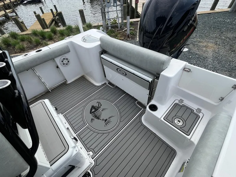 Slide: The Image of 2020 Sportsman Open 232 Center Console boat interior with seating and storage, dockside view. - 14