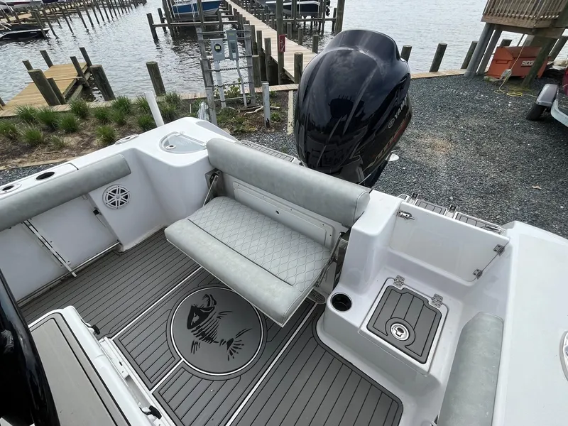 Slide: The Image of 2020 Sportsman Open 232 Center Console boat interior with seating and engine, dockside view. - 15