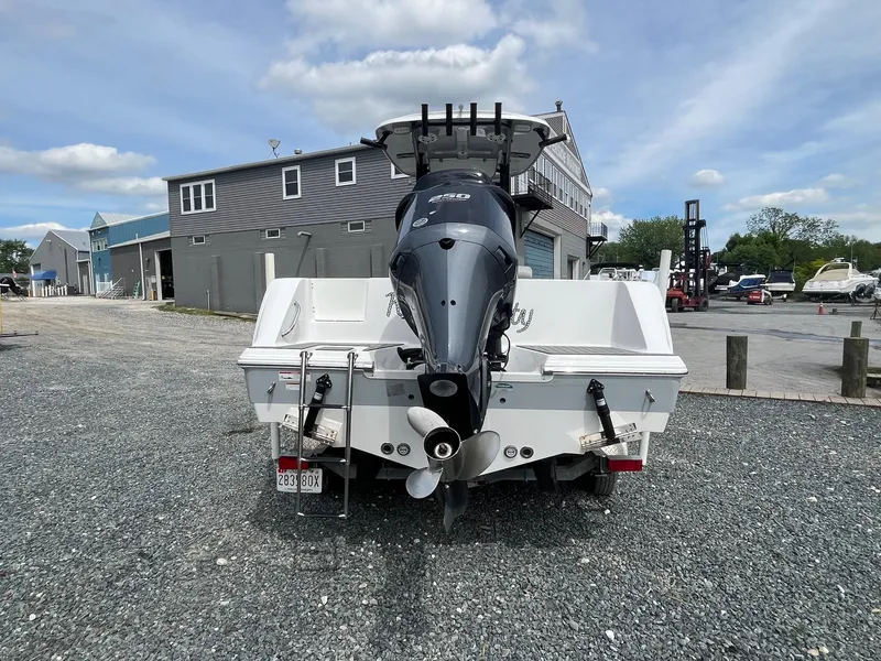 Slide: The Image of 2020 Sportsman Open 232 Center Console boat with outboard motor, parked on gravel lot. - 3