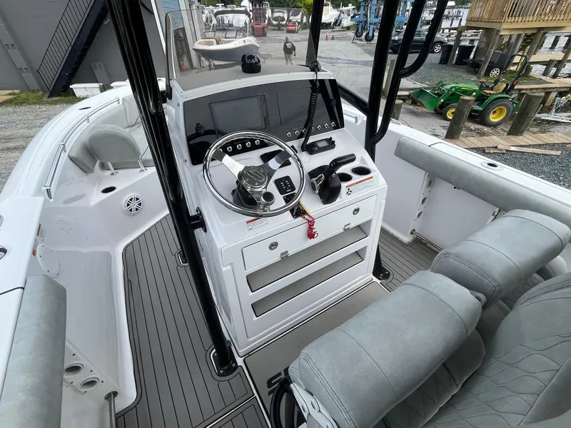 Slide: The Image of 2020 Sportsman Open 232 Center Console boat interior with steering wheel and seating. - 7