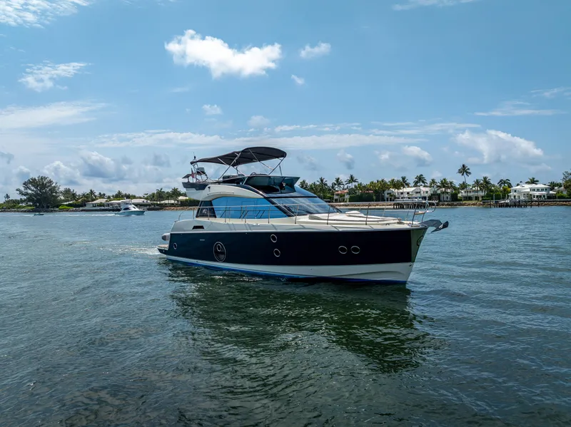 Slide: The Image of 2015 Beneteau Monte Carlo 5 yacht cruising on a sunny day near a coastal area. - 12