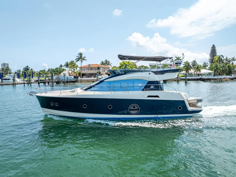 Slide: The Image of 2015 Beneteau Monte Carlo 5 yacht cruising on a sunny day near a tropical shoreline. - 25