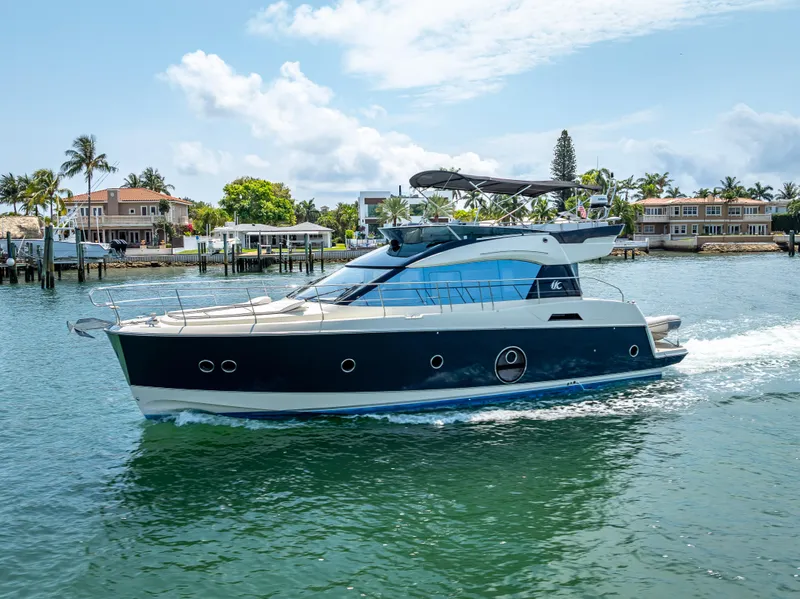 Slide: The Image of 2015 Beneteau Monte Carlo 5 yacht cruising on a sunny day near waterfront homes. - 26