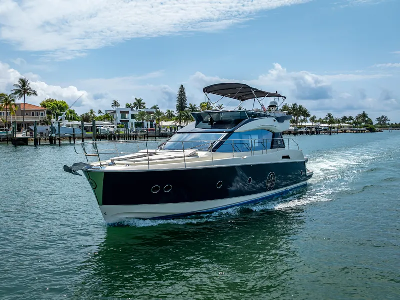 Slide: The Image of 2015 Beneteau Monte Carlo 5 yacht cruising on a sunny day near waterfront homes. - 27