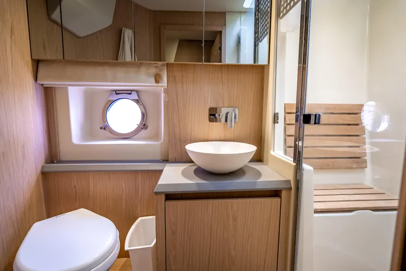 Slide: The Image of Luxurious bathroom interior of 2015 Beneteau Monte Carlo 5 yacht, featuring modern fixtures and wood accents. - 38