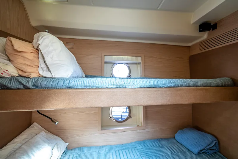 Slide: The Image of Bunk beds in 2015 Beneteau Monte Carlo 5 yacht cabin with porthole window. - 49
