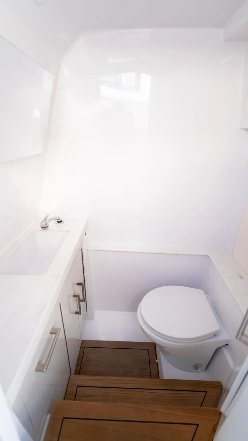 Slide: The Image of Compact bathroom in 2026 Jupiter 32 model boat with white fixtures and wooden steps. - 10