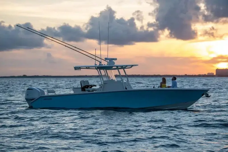 Slide: The Image of 2026 Jupiter 32 boat on water at sunset, featuring fishing rods and two people onboard. - 14