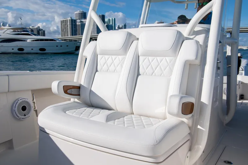 Slide: The Image of Luxurious white seating on a 2026 Jupiter 32 boat, with yachts and city skyline in the background. - 8
