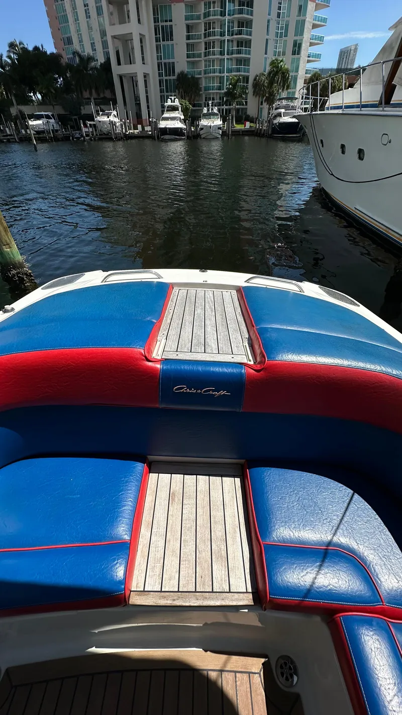 Slide: The Image of 2009 Chris-Craft Corsair 25 boat with blue and red seating, docked in a marina. - 20
