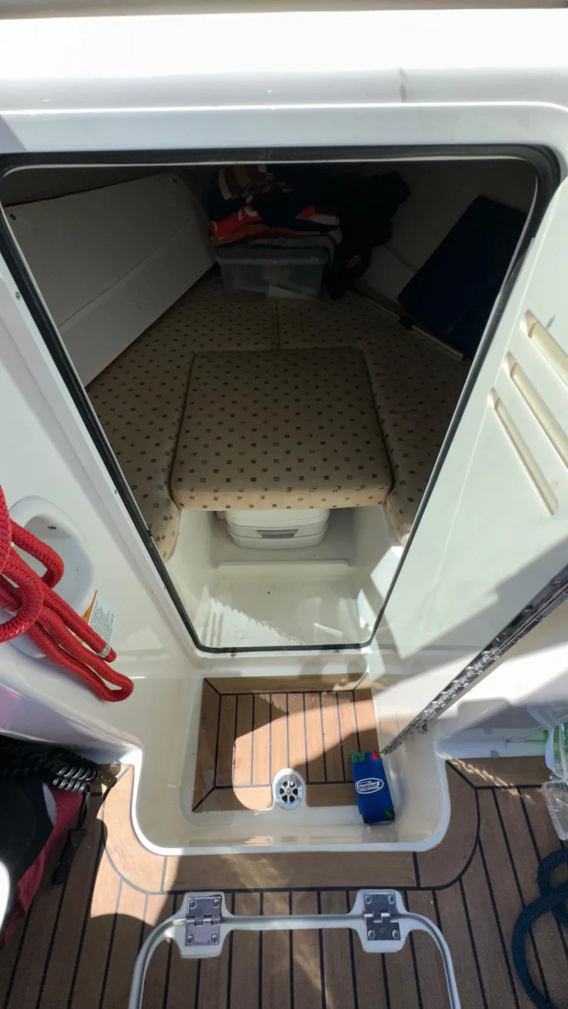 Slide: The Image of 2009 Chris-Craft Corsair 25 cabin interior with cushioned seating and wooden flooring. - 24