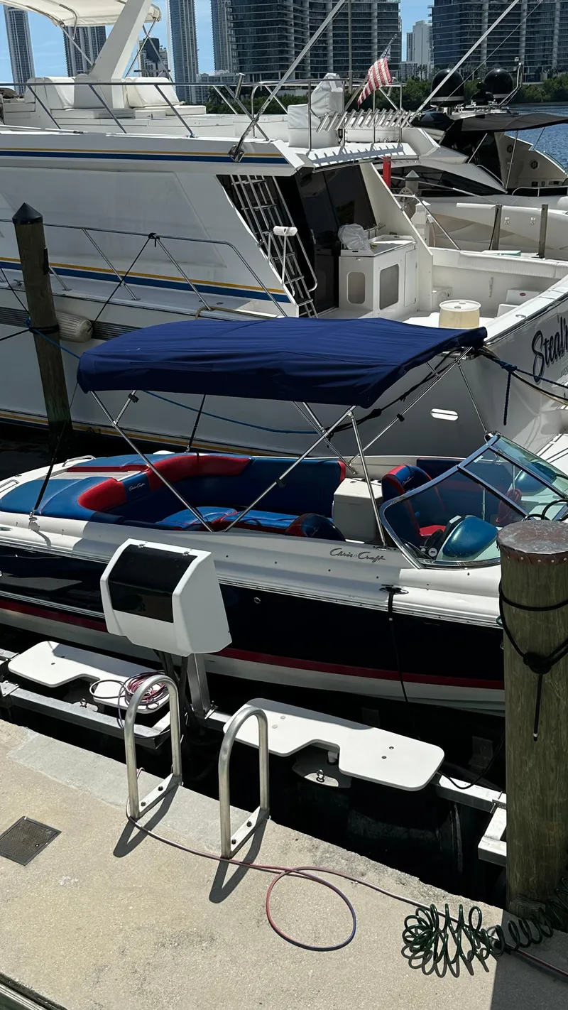 Slide: The Image of 2009 Chris-Craft Corsair 25 docked, featuring a blue canopy and sleek design. - 26