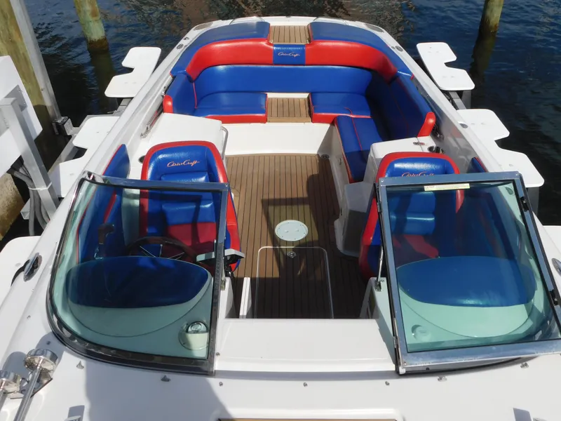 Slide: The Image of 2009 Chris-Craft Corsair 25 boat with red and blue seating, docked on water. - 31