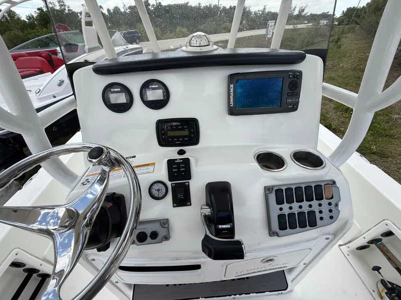 Slide: The Image of 2015 NauticStar 244 XTS boat dashboard with steering wheel, gauges, and navigation system. - 10