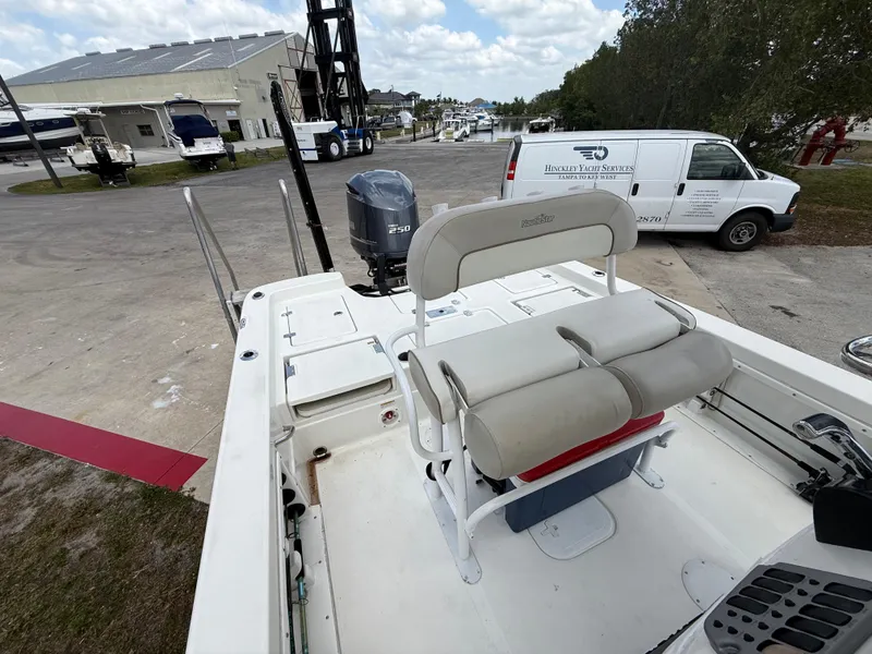 Slide: The Image of 2015 NauticStar 244 XTS boat with seating and outboard motor, parked near industrial area. - 11