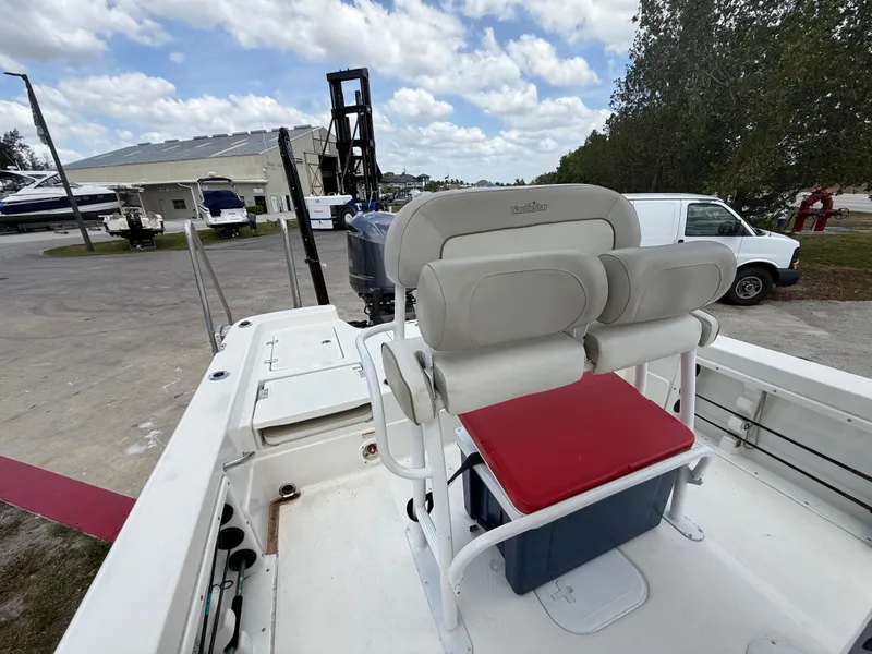 Slide: The Image of 2015 NauticStar 244 XTS boat with seating and storage, docked outdoors. - 12
