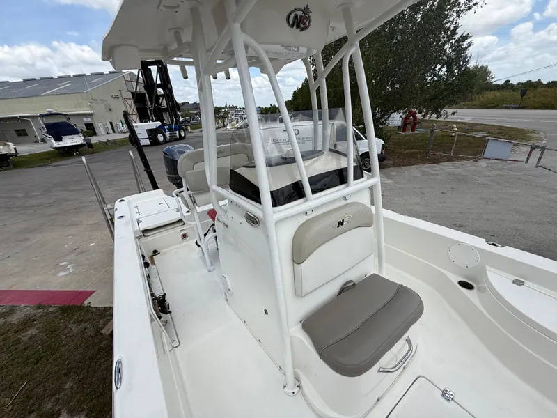 Slide: The Image of 2015 NauticStar 244 XTS boat with white interior and seating, parked outdoors. - 14