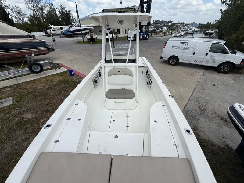 Slide: The Image of 2015 NauticStar 244 XTS boat at marina, featuring spacious deck and seating. - 15