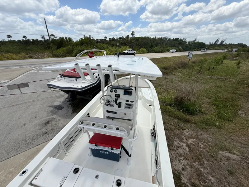Slide: The Image of 2015 NauticStar 244 XTS boat parked on roadside under cloudy sky. - 5