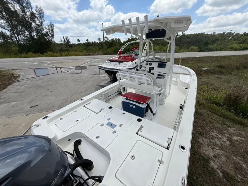 Slide: The Image of 2015 NauticStar 244 XTS boat with center console and outboard motor, parked on a sunny day. - 6