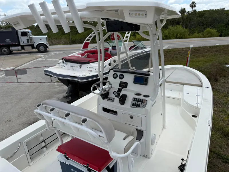 Slide: The Image of 2015 NauticStar 244 XTS boat with center console and seating, parked near other boats. - 8
