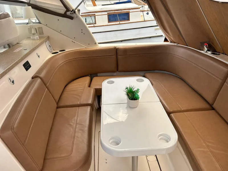 Slide: The Image of 2005 Rinker Fiesta Vee 410 interior with tan seating and white table. - 11