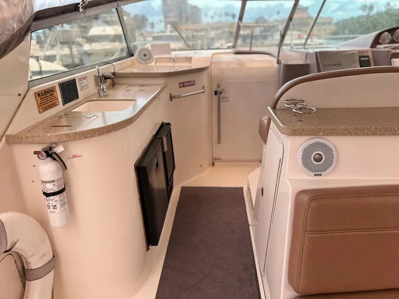 Slide: The Image of 2005 Rinker Fiesta Vee 410 yacht interior with kitchenette and seating area. - 15