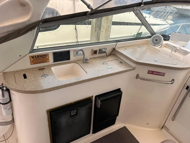 Slide: The Image of 2005 Rinker Fiesta Vee 410 boat kitchenette with sink, mini fridge, and countertop. - 16