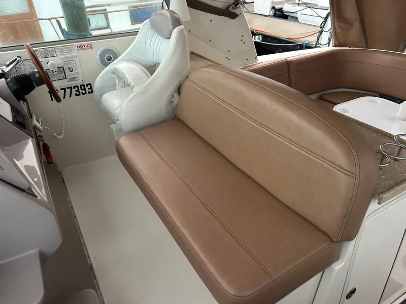 Slide: The Image of 2005 Rinker Fiesta Vee 410 boat interior with beige seating and white captain's chair. - 17