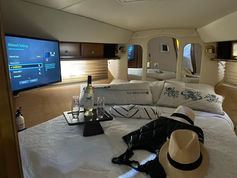 Slide: The Image of Luxurious 2005 Rinker Fiesta Vee 410 cabin with cozy bed, TV, and wine setup. - 18