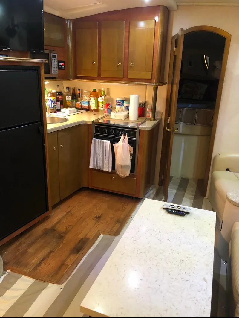 Slide: The Image of 2005 Rinker Fiesta Vee 410 interior kitchen with wooden cabinets and modern appliances. - 21