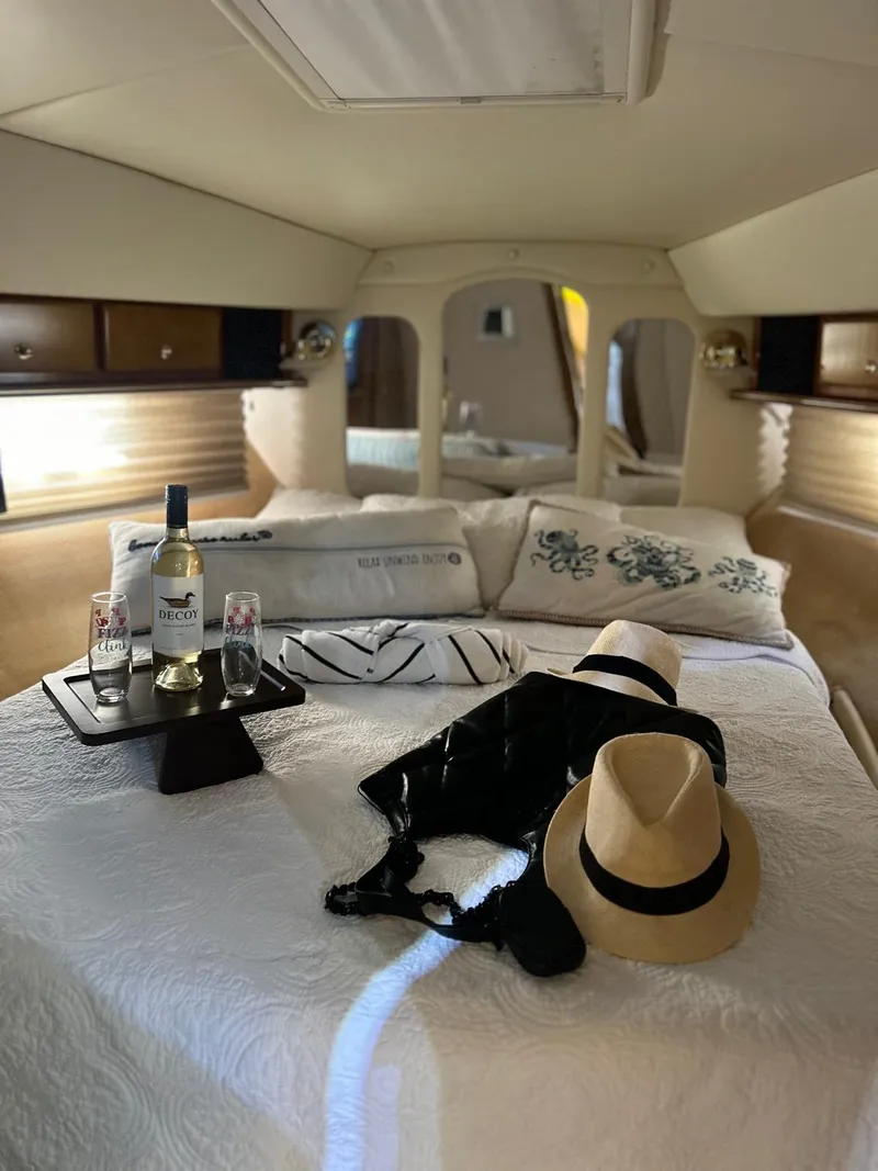 Slide: The Image of Interior of 2005 Rinker Fiesta Vee 410 with cozy bed, wine, and hat. - 22