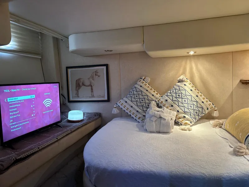 Slide: The Image of Cozy cabin interior of 2005 Rinker Fiesta Vee 410 with bed, TV, and decorative pillows. - 27