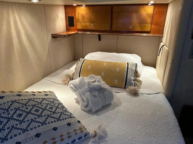 Slide: The Image of Cozy cabin interior of 2005 Rinker Fiesta Vee 410 with plush bedding and ambient lighting. - 29