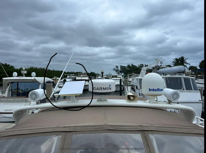 Slide: The Image of 2005 Rinker Fiesta Vee 410 boat with Garmin and Intellian equipment, docked under cloudy skies. - 3