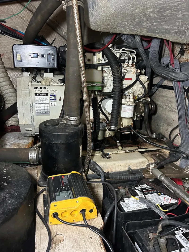 Slide: The Image of Engine room of a 2005 Rinker Fiesta Vee 410 with visible generator and battery components. - 31