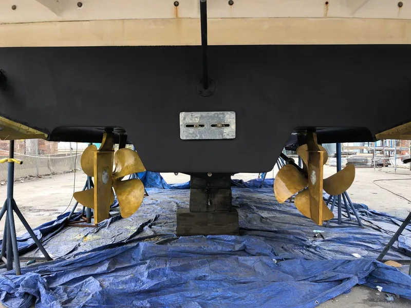 Slide: The Image of 2005 Rinker Fiesta Vee 410 boat underside with dual propellers on a blue tarp. - 4