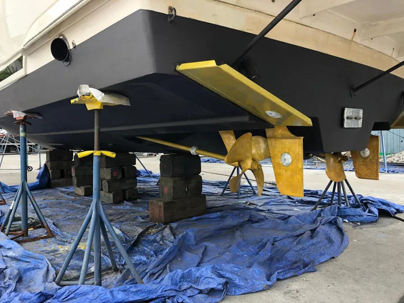 Slide: The Image of 2005 Rinker Fiesta Vee 410 boat on stands, showing propellers and hull maintenance. - 5