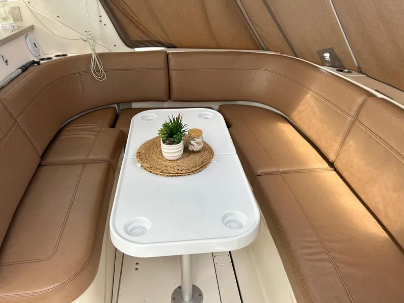 Slide: The Image of 2005 Rinker Fiesta Vee 410 interior with brown seating and white table. - 7