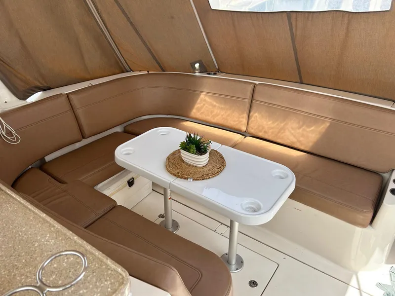 Slide: The Image of 2005 Rinker Fiesta Vee 410 interior with beige seating and white table. - 8