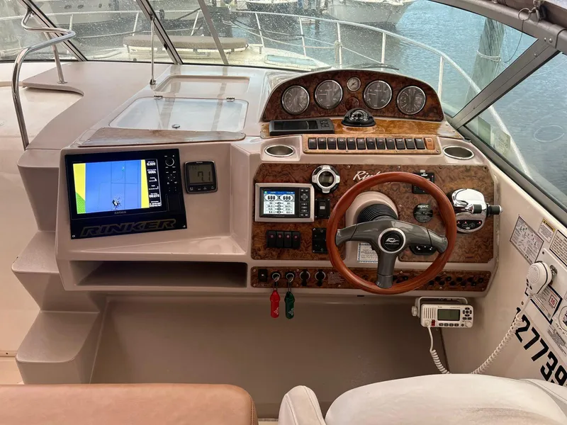 Slide: The Image of 2005 Rinker Fiesta Vee 410 boat dashboard with navigation system and wooden steering wheel. - 9